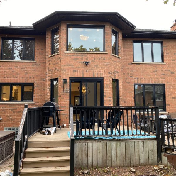 Black replacement windows and sliding patio door installed on a two-storey home in King City, ON